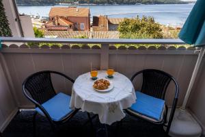 une table avec deux chaises et une assiette de nourriture sur un balcon dans l'établissement Wonderful House Sandra, à Mali Lošinj
