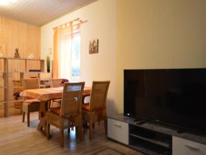 a living room with a dining table and a flat screen tv at Cosy Apartment in Manderscheid with Balcony in Manderscheid