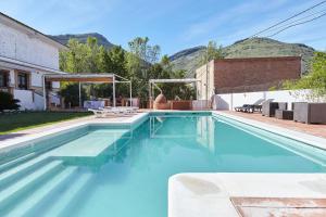 een zwembad met blauw water in een huis bij El Ranchito in Jamilena