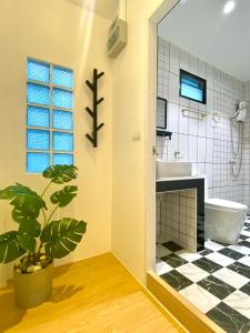 een badkamer met een plant, een bad en een wastafel bij Minimal1 MaeHaad in Ko Tao