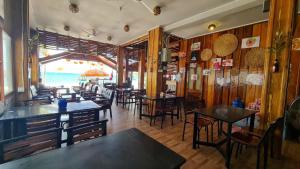 a restaurant with tables and chairs and a view of the beach at Koh Rong Homestay in Kaôh Rŭng (3)