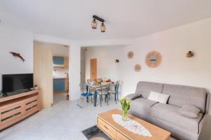 a living room with a couch and a table at La maison bleue - Erquy - Piscine couverte in Erquy