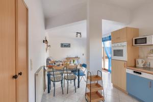 a kitchen and dining room with a table and chairs at La maison bleue - Erquy - Piscine couverte in Erquy