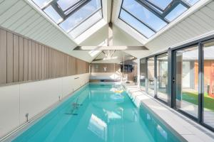 an indoor swimming pool with a skylight in a house at La maison bleue - Erquy - Piscine couverte in Erquy