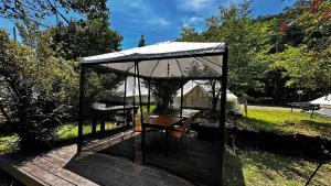 einen Pavillon mit einer Holzterrasse mit einem Tisch in der Unterkunft Shimanto Yamamizuki - Vacation STAY 36953v in Shimanto