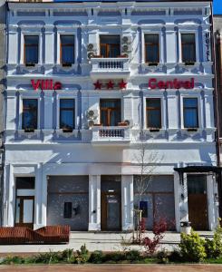 un edificio blanco con un letrero rojo. en Vila Central, en Constanţa