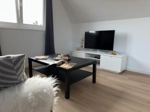 a living room with a coffee table and a tv at Duinroos vlakbij strand in Egmond aan Zee