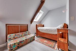 een slaapkamer met een bed en een bank in een kamer bij Maison avec jardin pour 6 entre golf et plage in Saint-Gildas-de-Rhuys