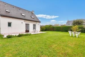 een huis met een tuin met tafels en stoelen bij Maison avec jardin pour 6 entre golf et plage in Saint-Gildas-de-Rhuys