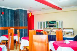 a dining room with tables and chairs and red walls at After 40 Hotel in Nairobi