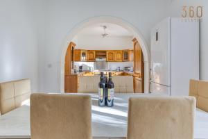 a kitchen with two bottles of wine sitting on a table at Stunning 4BR Villa with private terrace in Balzan by 360 Estates in Balzan