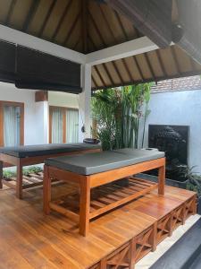 una camera con due tavoli da massaggio su un pavimento in legno di Villa Casablanca Surf Keramas a Keramas Altre 103 foto