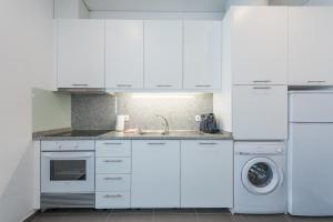 una cucina bianca con lavandino e lavastoviglie di GuestReady - Spacious modern stay in Porto a Vila Nova de Gaia
