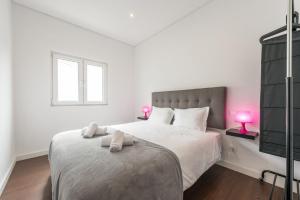 una camera bianca con un grande letto con due lampade rosa di GuestReady - Spacious modern stay in Porto a Vila Nova de Gaia