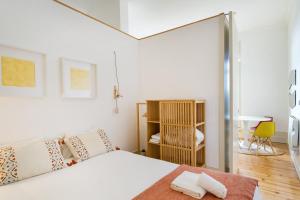 Dormitorio blanco con cama y puerta corredera de cristal en GuestReady - Urban oasis with private balcony, en Oporto