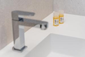 dos botellas de miel sentadas en el lavabo del baño en GuestReady - Modern luxe getaway in Vitória en Oporto