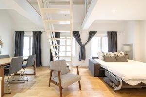 a bedroom with a bed and a ladder and a desk at The Doms Flats in Brussels