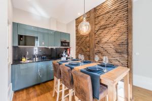 eine Küche mit einem Holztisch mit blauen Schränken in der Unterkunft GuestReady - Modern luxe getaway in Vitória in Porto