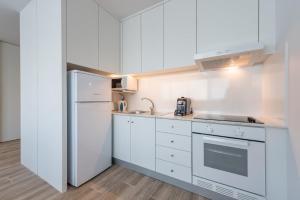 a kitchen with white cabinets and a refrigerator at GuestReady - Retreat near Matosinhos beach in Matosinhos