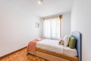 Schlafzimmer mit einem Bett und einem Fenster in der Unterkunft GuestReady - Eclectic haven in the heart of Porto in Porto