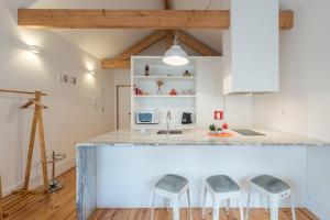 a kitchen with a counter and two stools at GuestReady - Chic city nest in Porto in Porto