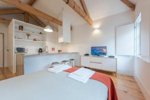 a white kitchen with a large bed in a room at GuestReady - Chic city nest in Porto in Porto