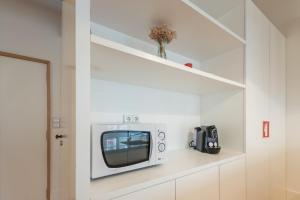 a small white microwave in a white wall at GuestReady - Chic city nest in Porto in Porto