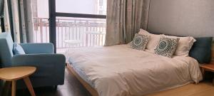 a bedroom with a bed and a chair and a window at Hangzhou Citynest Music B&B in Hangzhou