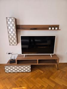a living room with a entertainment center with a tv at Júlia Apartman Kaposvár*** in Kaposvár
