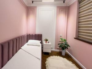 a pink room with a bed and a table at Modern Lux 2 in Samarkand