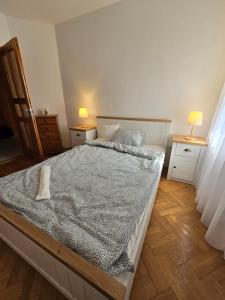 a large bed in a bedroom with two lamps on tables at Júlia Apartman Kaposvár*** in Kaposvár