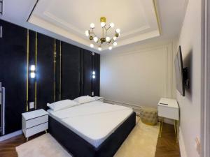 a bedroom with a large bed and a chandelier at Modern Lux 2 in Samarkand