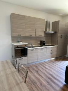 a kitchen with wooden cabinets and a table with chairs at CA DEL TRIMA in Melegnano