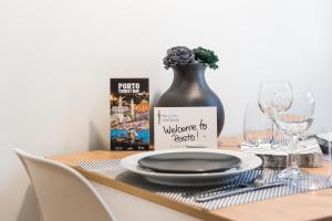 a table with a plate and a book and wine glasses at GuestReady - Private oasis for two in Porto