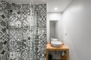 a bathroom with a sink and a glass shower at GuestReady - Private oasis for two in Porto