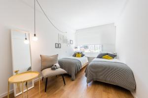 a bedroom with two beds and a table and a chair at GuestReady - Chic and cozy getaway in Porto
