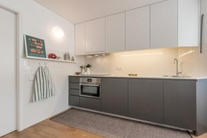 a kitchen with white cabinets and a sink at GuestReady - Chic and cozy getaway in Porto