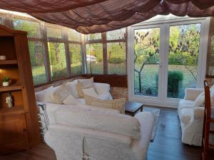 uma sala de estar com um sofá branco e janelas em The family room at the bungalow em Willesborough