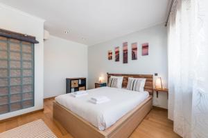 ポルトにあるGuestReady - Zen den in Lapaの白いベッドルーム(大型ベッド1台、窓付)