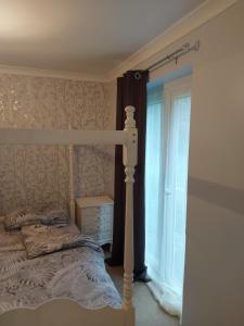 um quarto com uma cama e uma janela em The family room at the bungalow em Willesborough