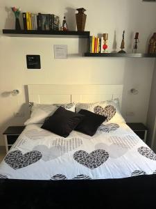 a bed with two heart pillows on it at A.R.L.A. House in Cogorno +22 photos