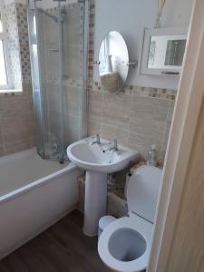 een badkamer met een wastafel, een toilet en een douche bij The family room at the bungalow in Willesborough