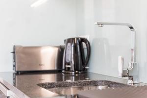eine Küchentheke mit Spüle und Kaffeemaschine in der Unterkunft GuestReady - Seaside getaway in Porto in Porto
