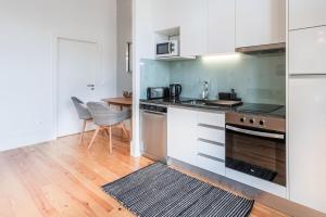 eine Küche mit weißen Schränken und einem Tisch und Stühlen in der Unterkunft GuestReady - Seaside getaway in Porto in Porto