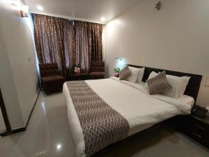 Un dormitorio con una cama grande y una ventana en Hotel Heritage 2001, Nagpur en Nagpur