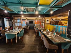 a restaurant with tables and chairs in a room at Hotel Heritage 2001, Nagpur in Nagpur