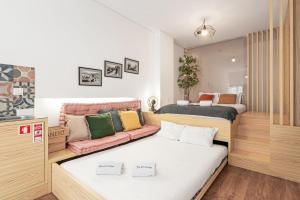 een kamer met 2 bedden en een bank bij GuestReady - Trendy city central studio in Porto