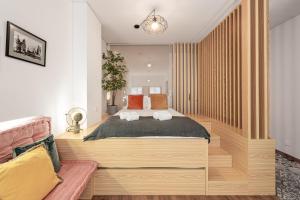 een slaapkamer met een groot bed en een bank bij GuestReady - Trendy city central studio in Porto