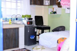 a small room with a bed and a microwave at Upper Haven Apartment in Kakamega