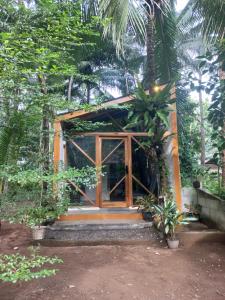 een klein huis met een deur in een bos bij Reureuh Cabin in Batukaras